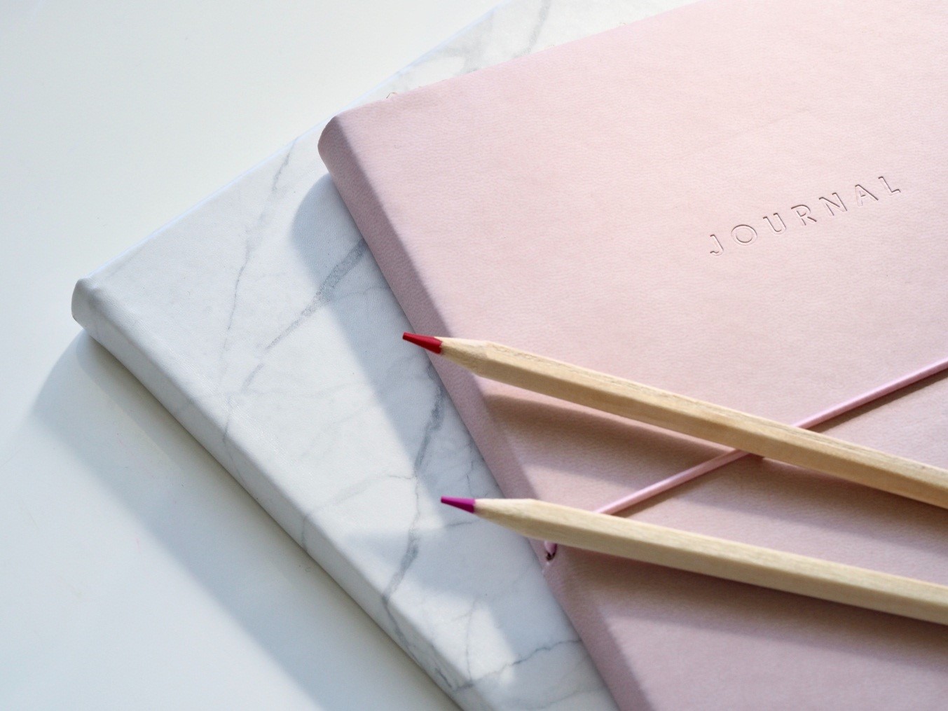pink color journal with colored pencils 